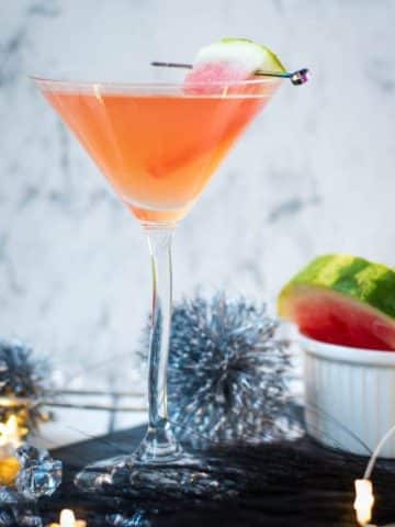 Gorgeous watermelon martini with a watermelon garnish, placed on a black slate plate.