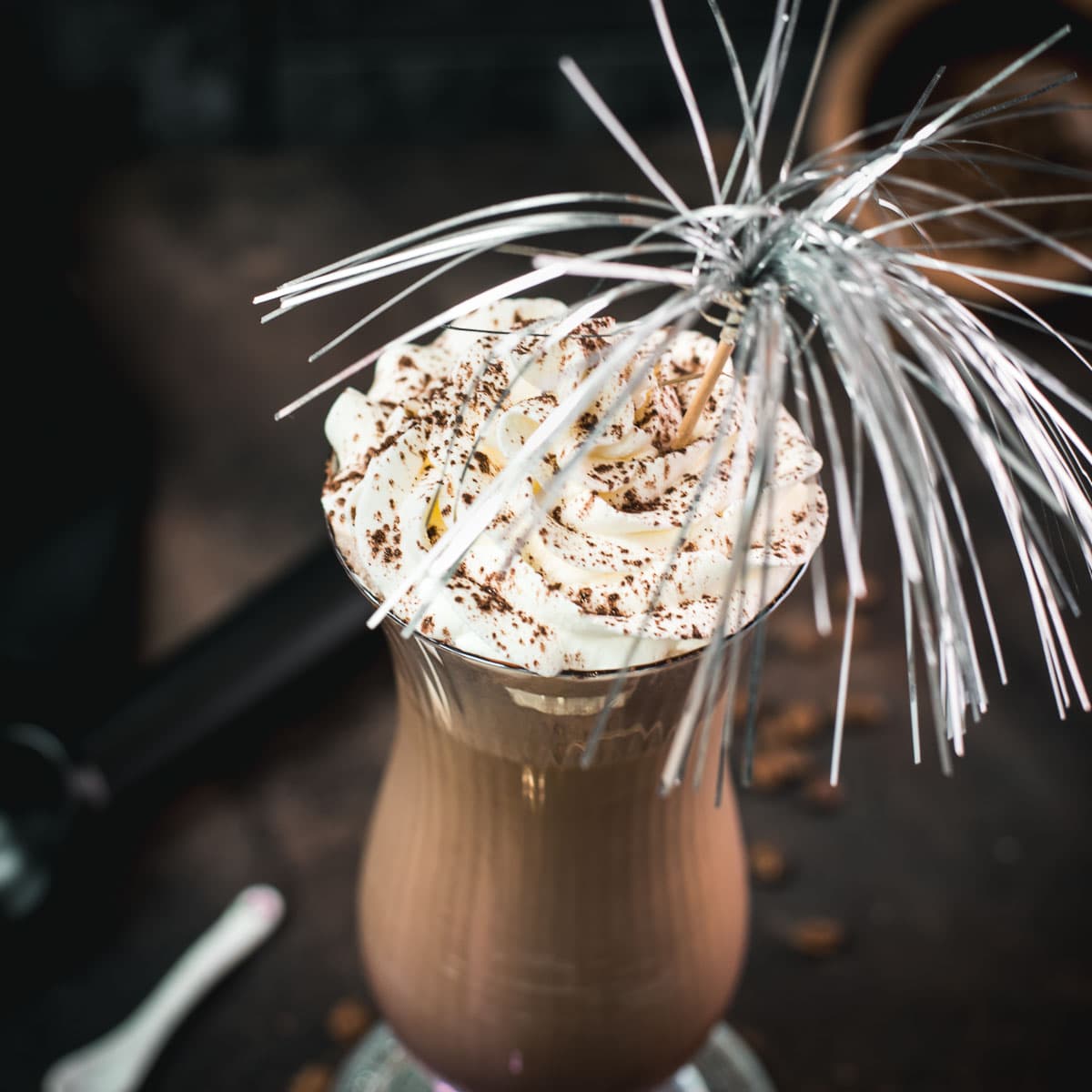Delicious iced chocolate coffee with sweet whipping cream on top. Dusted with cocoa powder and served in a hurricane glass.