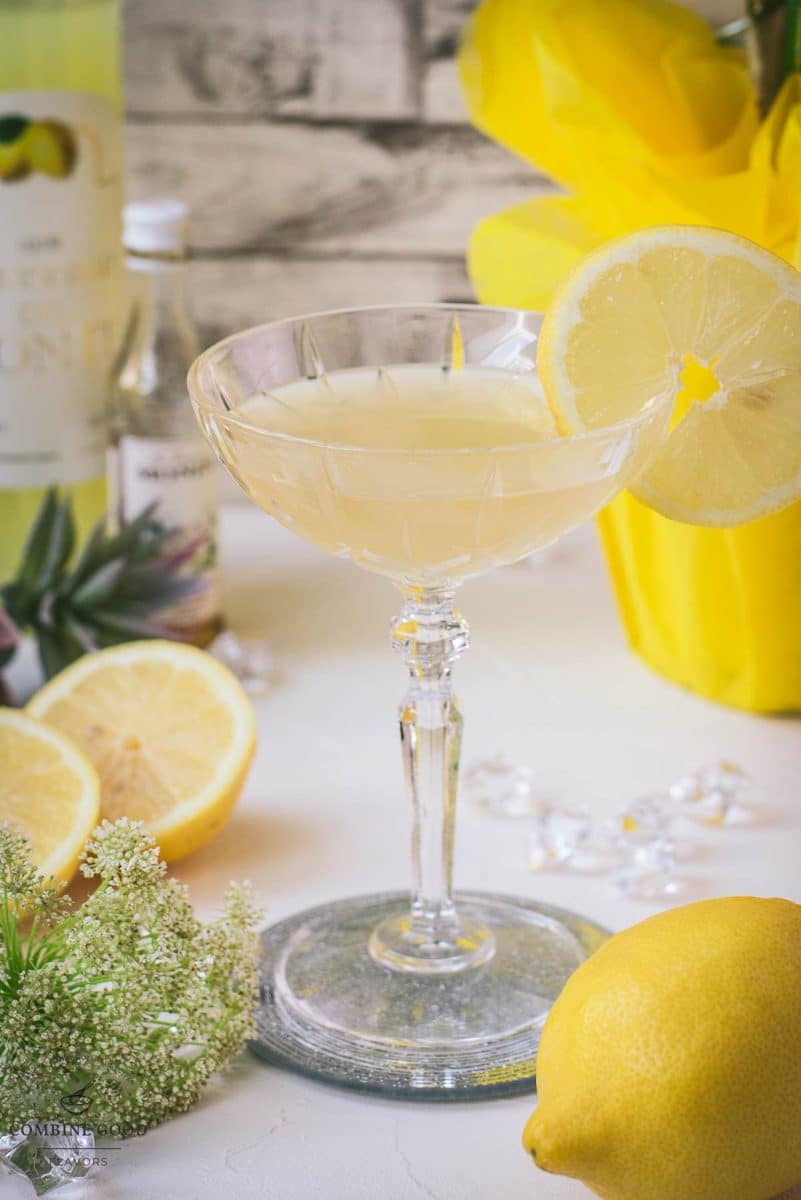 Gorgeous Limoncello Martini cocktail with elderflower syrup. Garnished with a lemon slice and placed on a mirrored coaster.