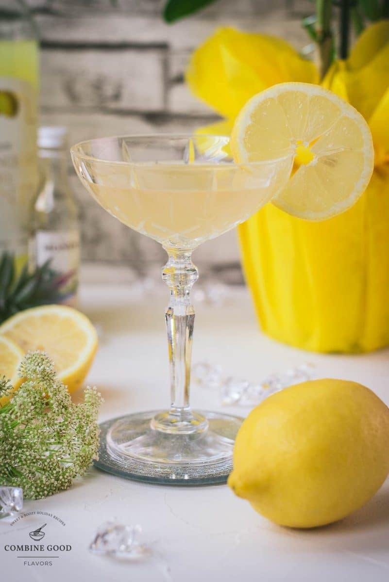 Gorgeous Limoncello Martini cocktail with elderflower syrup. Garnished with a lemon slice and placed on a mirrored coaster.