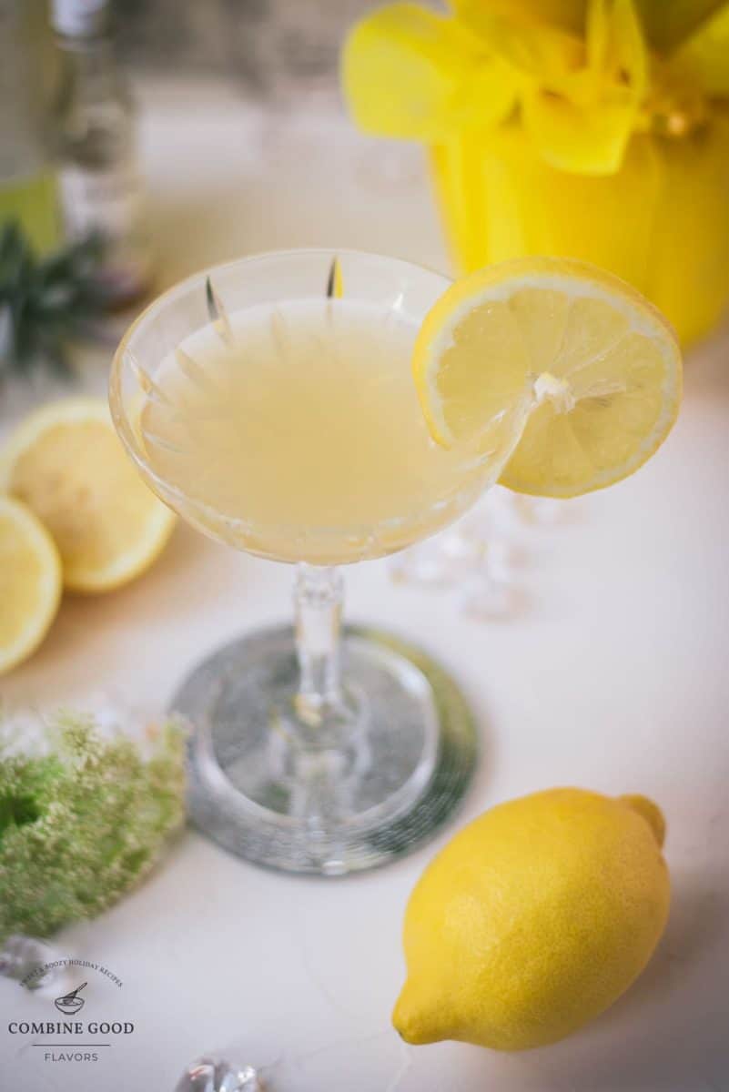 Gorgeous Limoncello Martini cocktail with elderflower syrup. Garnished with a lemon slice and placed on a mirrored coaster.