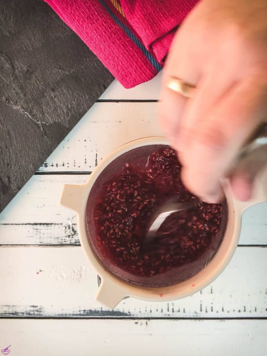 Pass the raspberry mixture through a sieve using a spoon.