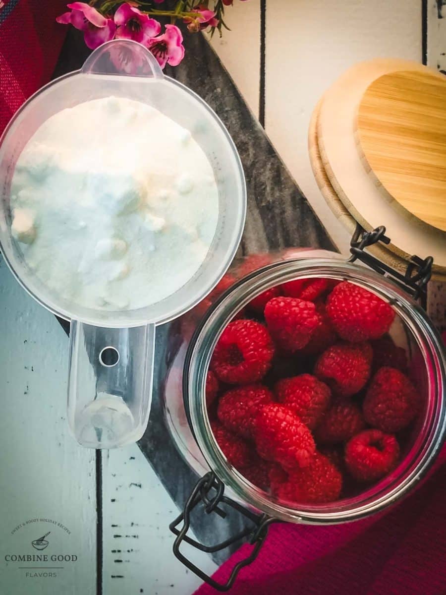 Ingredients for uncooked raspberry syrup - granulated sugar and fresh raspberries.