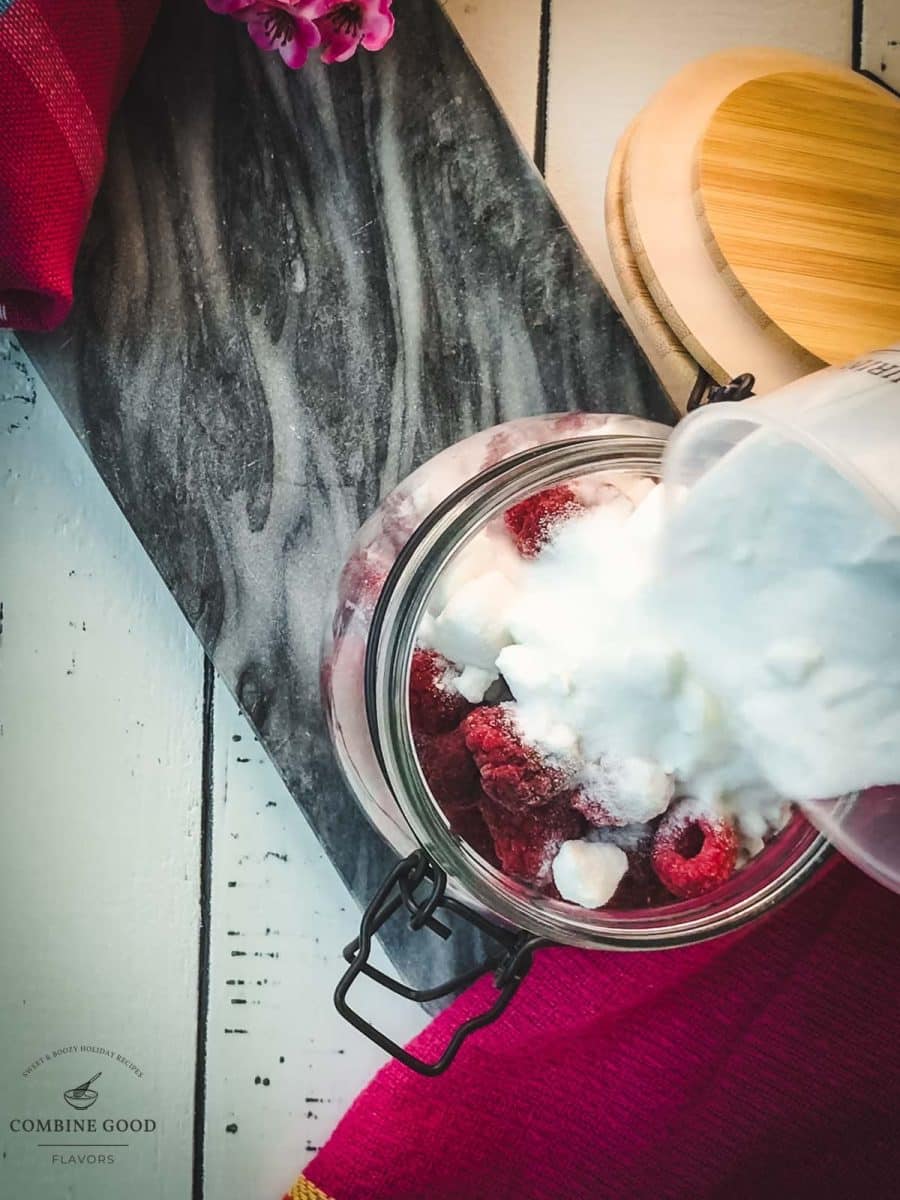 Filling the granulated sugar into the preserving jar filled with raspberries.