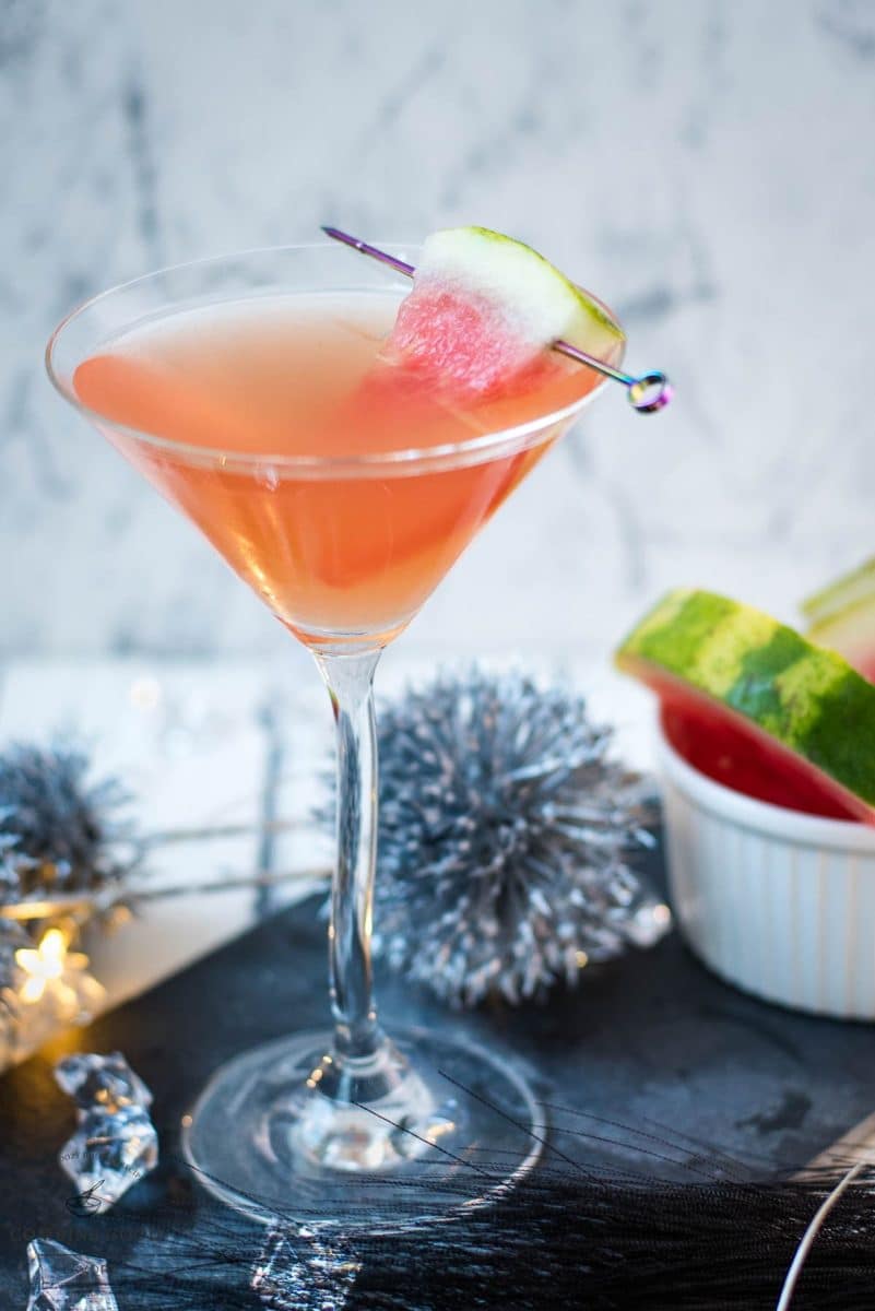 Gorgeous watermelon martini with a watermelon garnish, placed on a black slate plate.