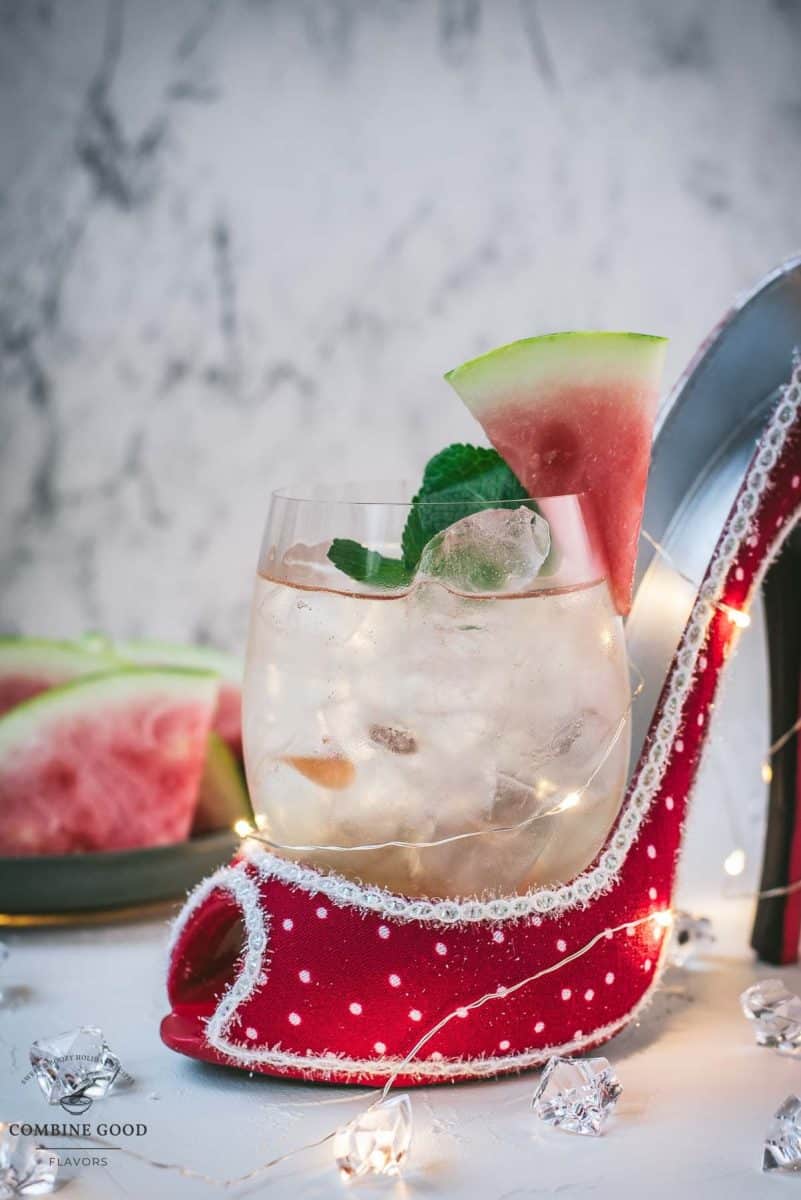 Delicious watermelon spritz with Prosecco placed in a red and white spotted high heel.