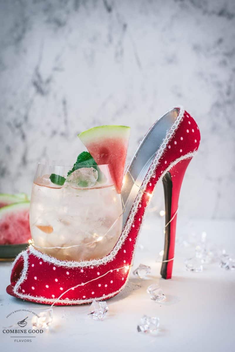 Delicious watermelon spritz with Prosecco placed in a red and white spotted high heel.