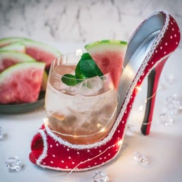 Delicious watermelon spritz with Prosecco placed in a red and white spotted high heel.