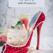 Delicious watermelon spritz with Prosecco placed in a red and white spotted high heel.