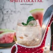 Delicious watermelon spritz with Prosecco placed in a red and white spotted high heel.