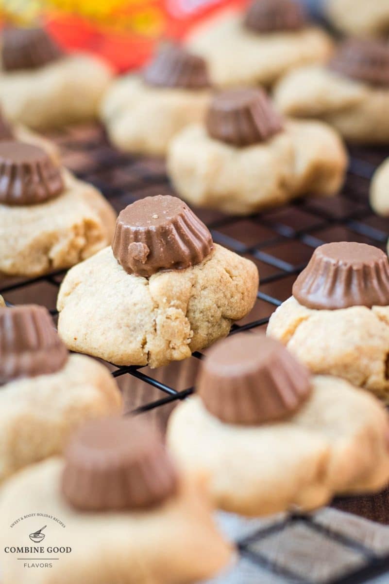 Utterly delicious Reese's peanut butter cookies placed on a cppling rack, with a Reese's peanut butter mini cup on top.