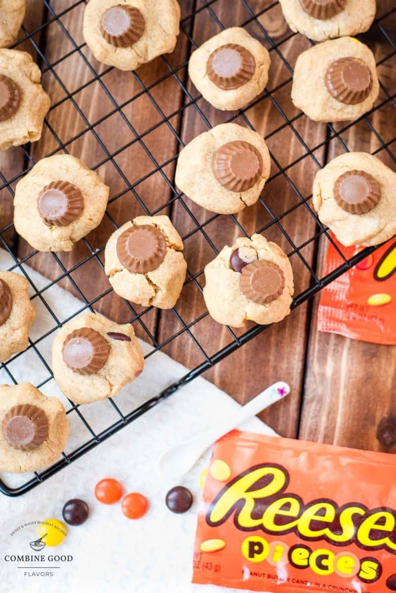 Utterly delicious Reese's peanut butter cookies placed on a cppling rack, with a Reese's peanut butter mini cup on top.