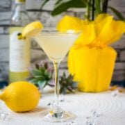 Gorgeous cocktail glass filled with a vibrant limoncello martini, garnished with a lemon wedge.