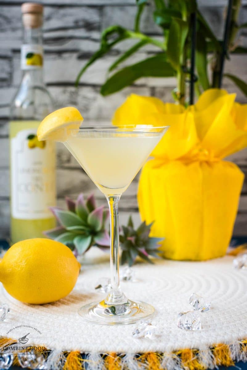 Gorgeous cocktail glass filled with a vibrant limoncello martini, garnished with a lemon wedge.