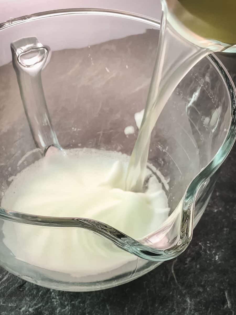 Pouring the lemon juice to the whipped egg white.