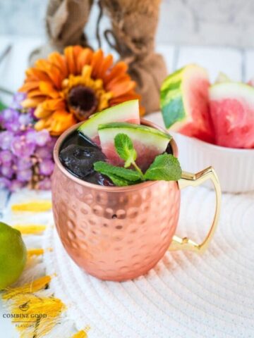 Gorgeous copper mug, filled with a delicious watermelon Moscow mule. Garnished with watermelon slices and mint leaves.