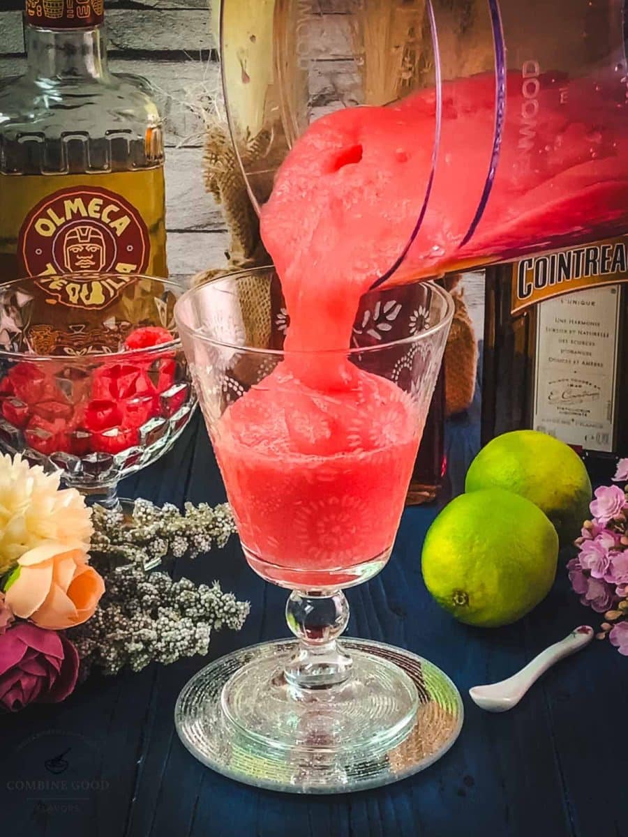 Pour the frozen raspberry margarita into the serving glasses.