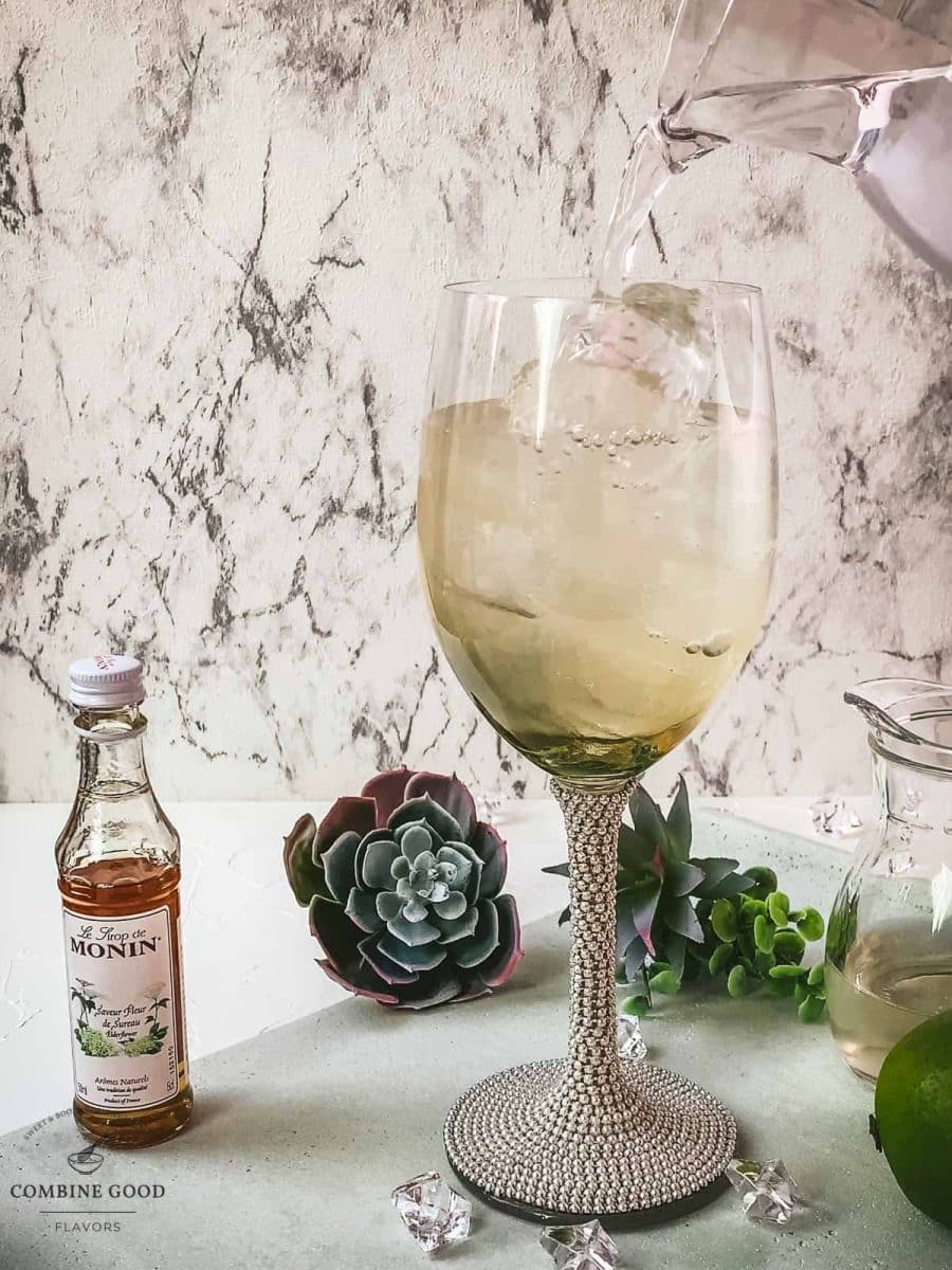 Pouring sparkling mineral water into the wine glass.