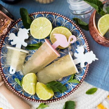 Gorgeous and refreshing Moscow mule popsicles placed on patterned plate.