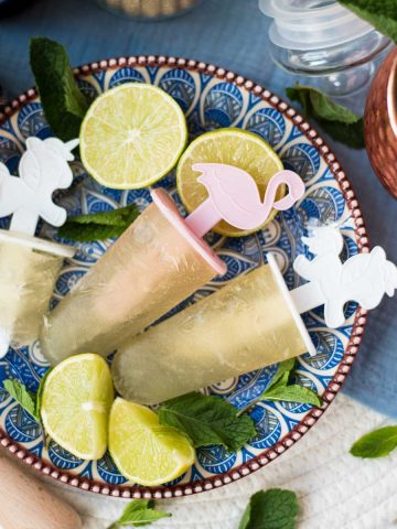 Gorgeous and refreshing Moscow mule popsicles placed on patterned plate.