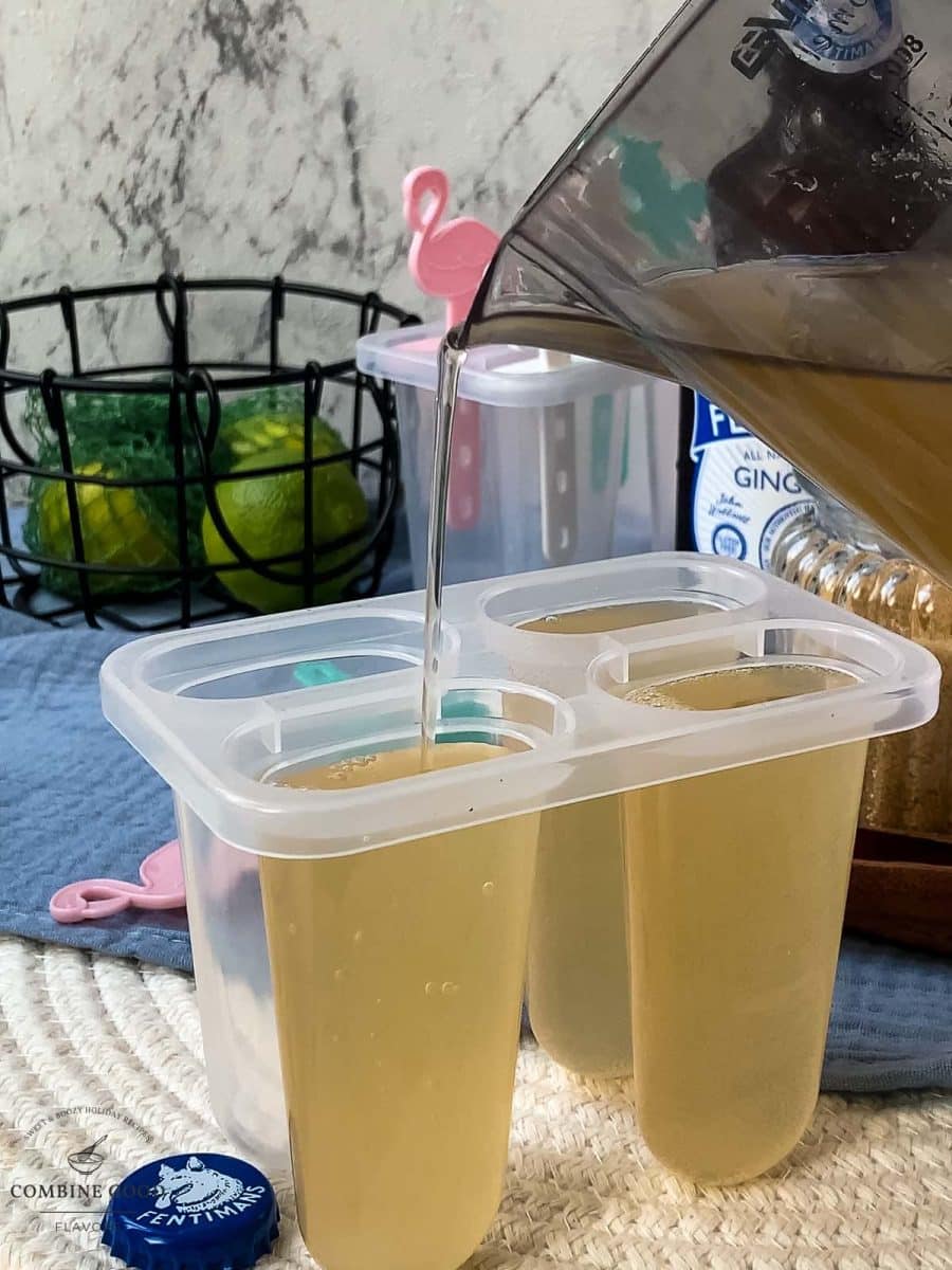 Pour the Moscow mule mix into the popsicle molds.