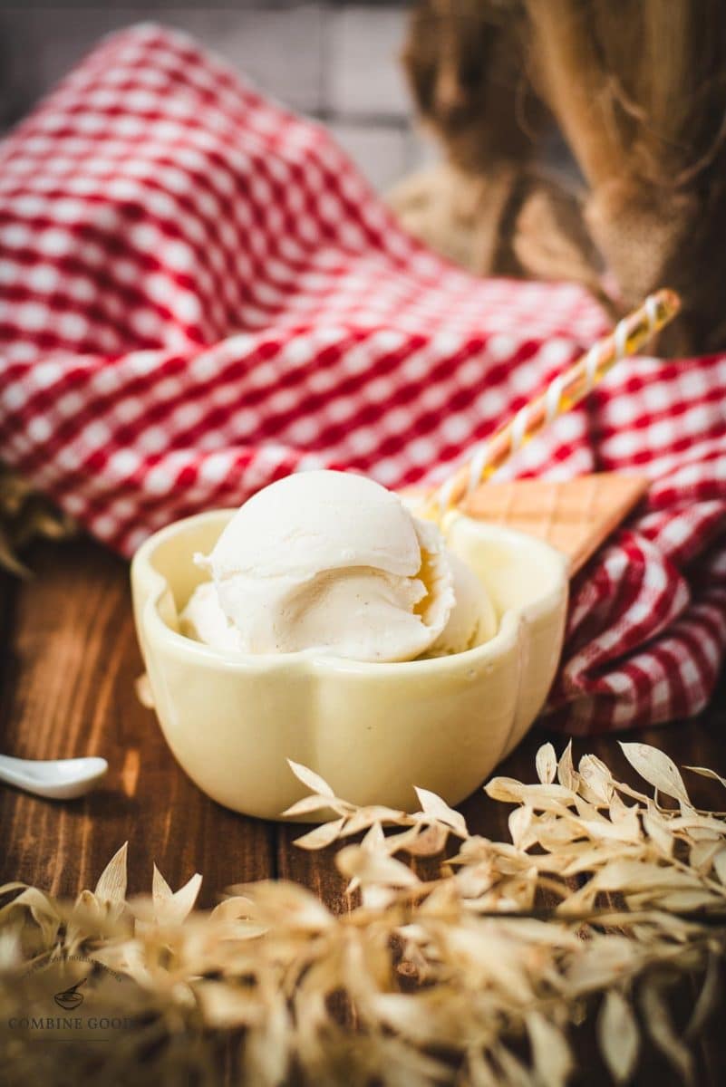 Delightful serving bowl filled with sour cream ice cream that looks like an ice cream cone with ice cream scoops. Placed on a brown wooden background.