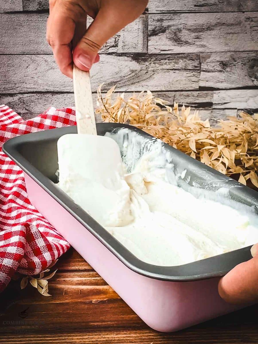 Spreading ice cream with a spatula into a loaf pan.