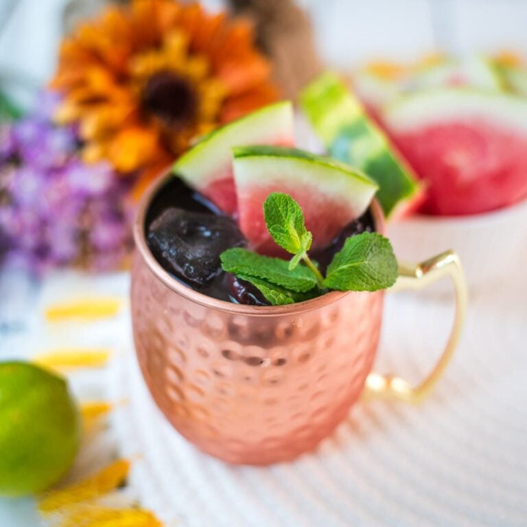 Gorgeous copper mug, filled with a delicious watermelon Moscow mule. Garnished with watermelon slices and mint leaves.