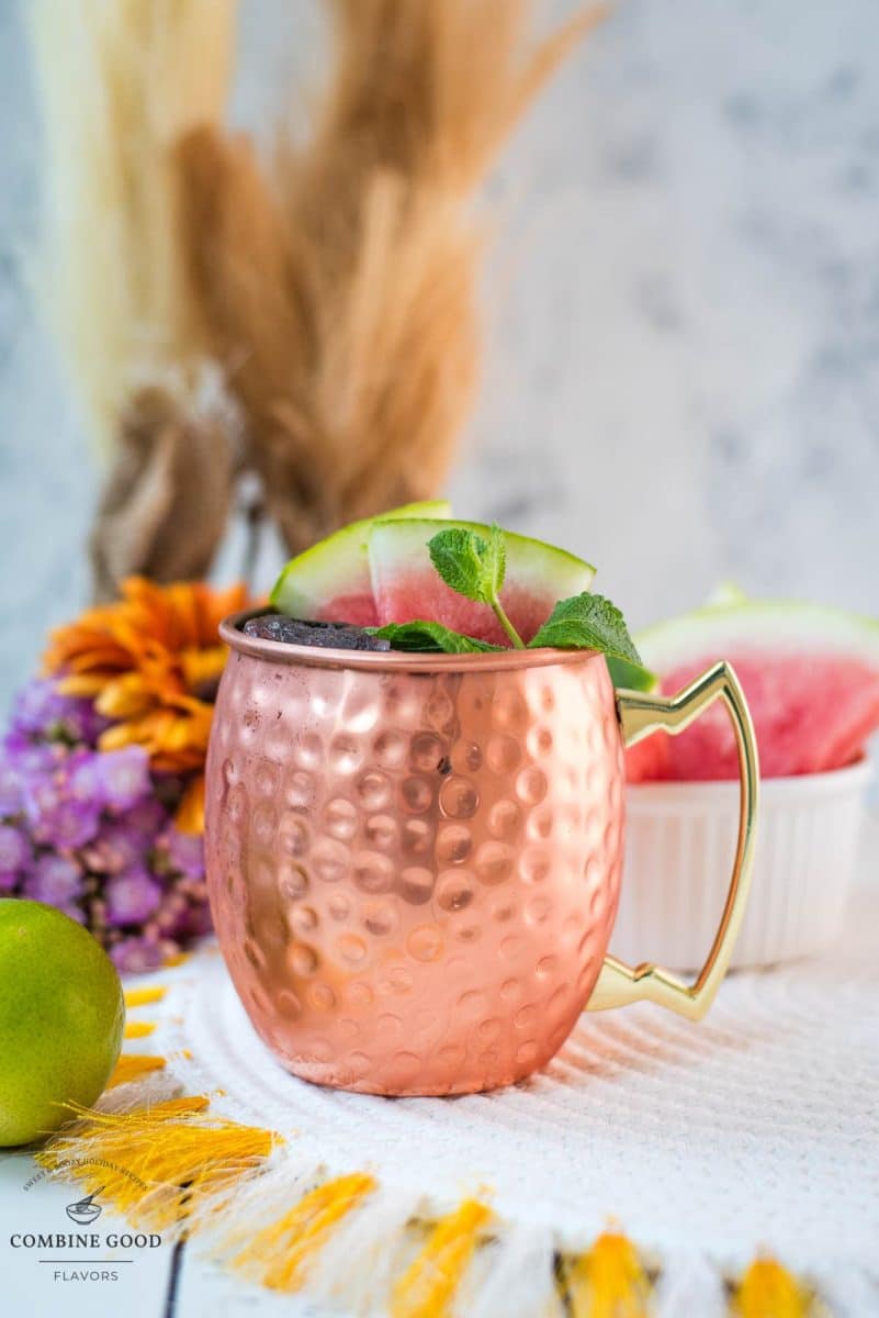 Gorgeous copper mug, filled with a delicious watermelon Moscow mule. Garnished with watermelon slices and mint leaves.