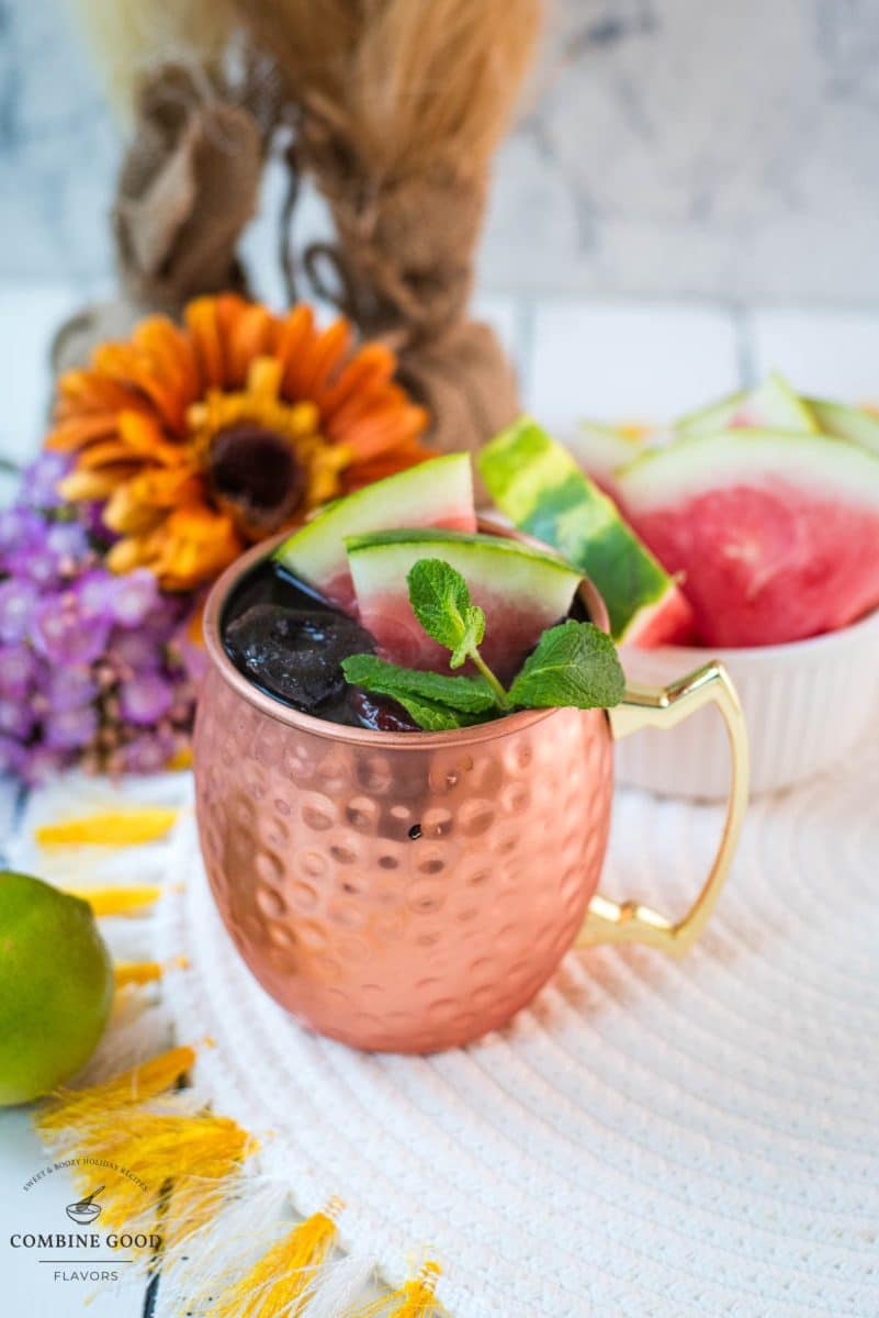 Gorgeous copper mug, filled with a delicious watermelon Moscow mule. Garnished with watermelon slices and mint leaves.