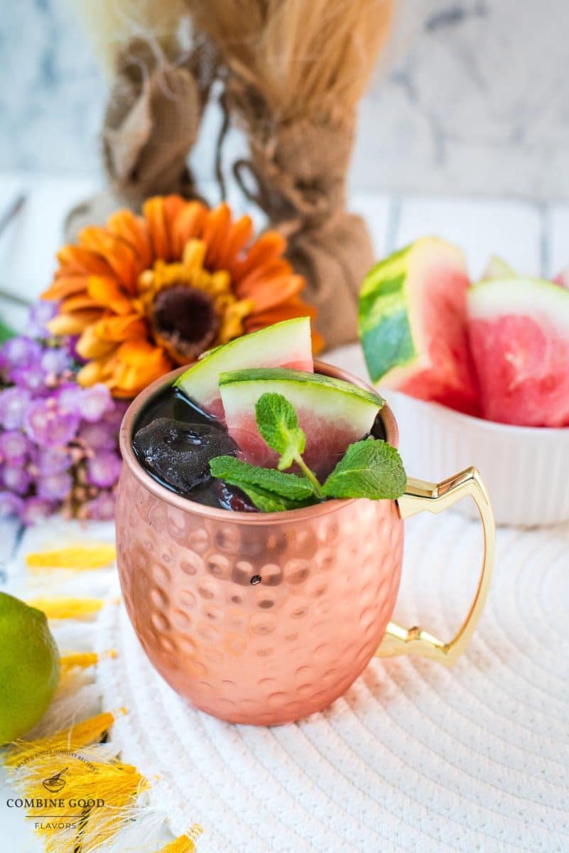 Gorgeous copper mug, filled with a delicious watermelon Moscow mule. Garnished with watermelon slices and mint leaves.