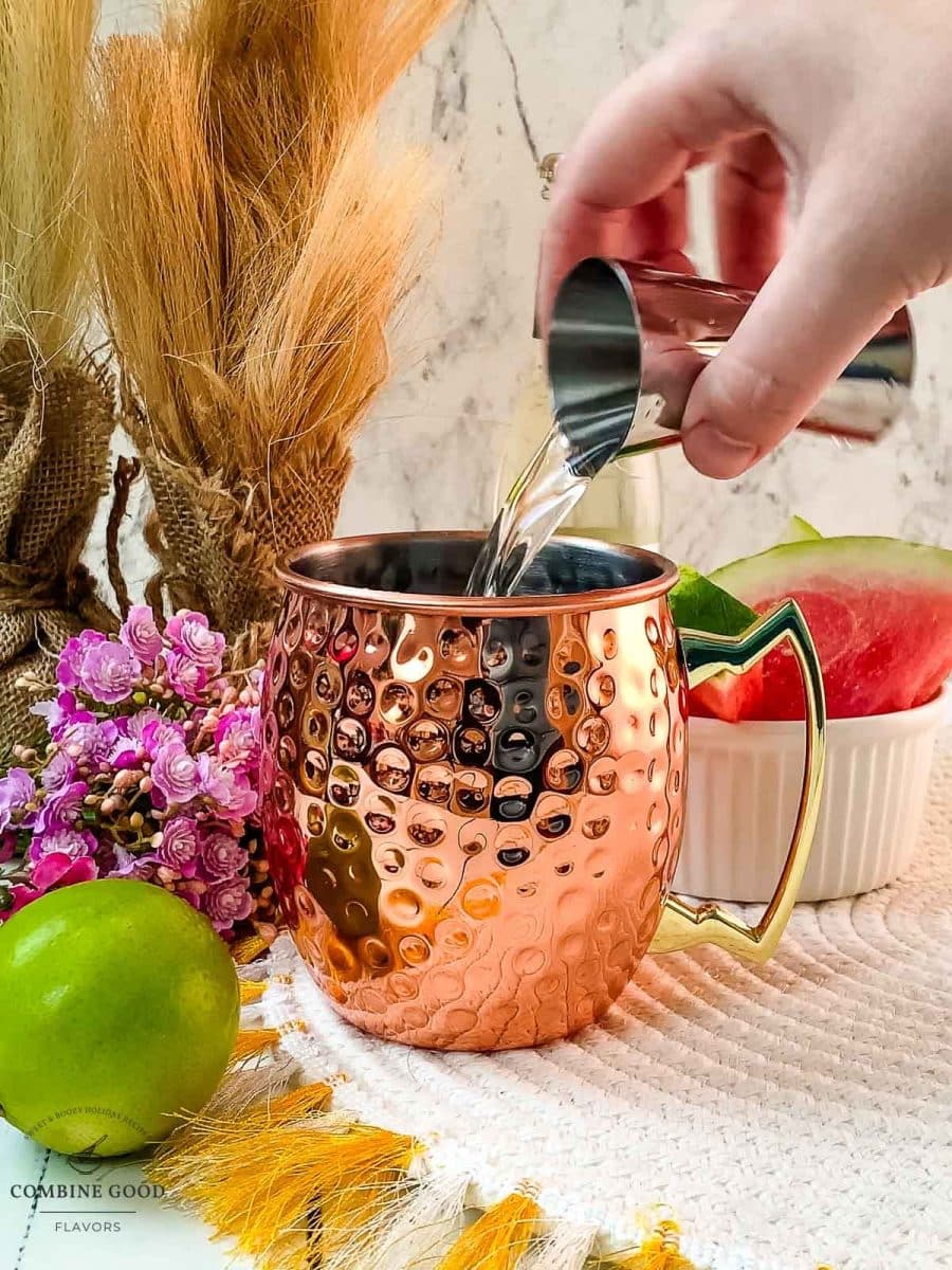 Adding vanilla vodka to the copper mug.