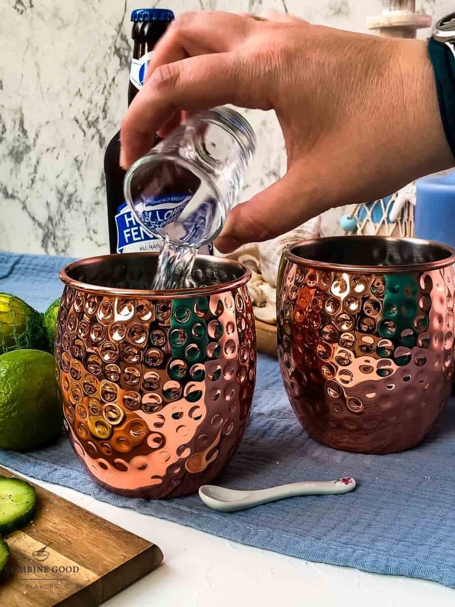 Add the vodka to the copper mugs.