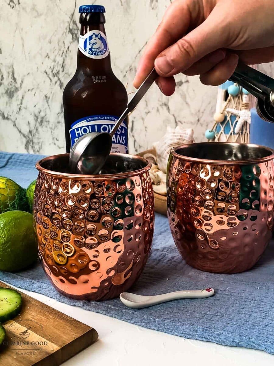 Add the lime juice to the copper mugs.