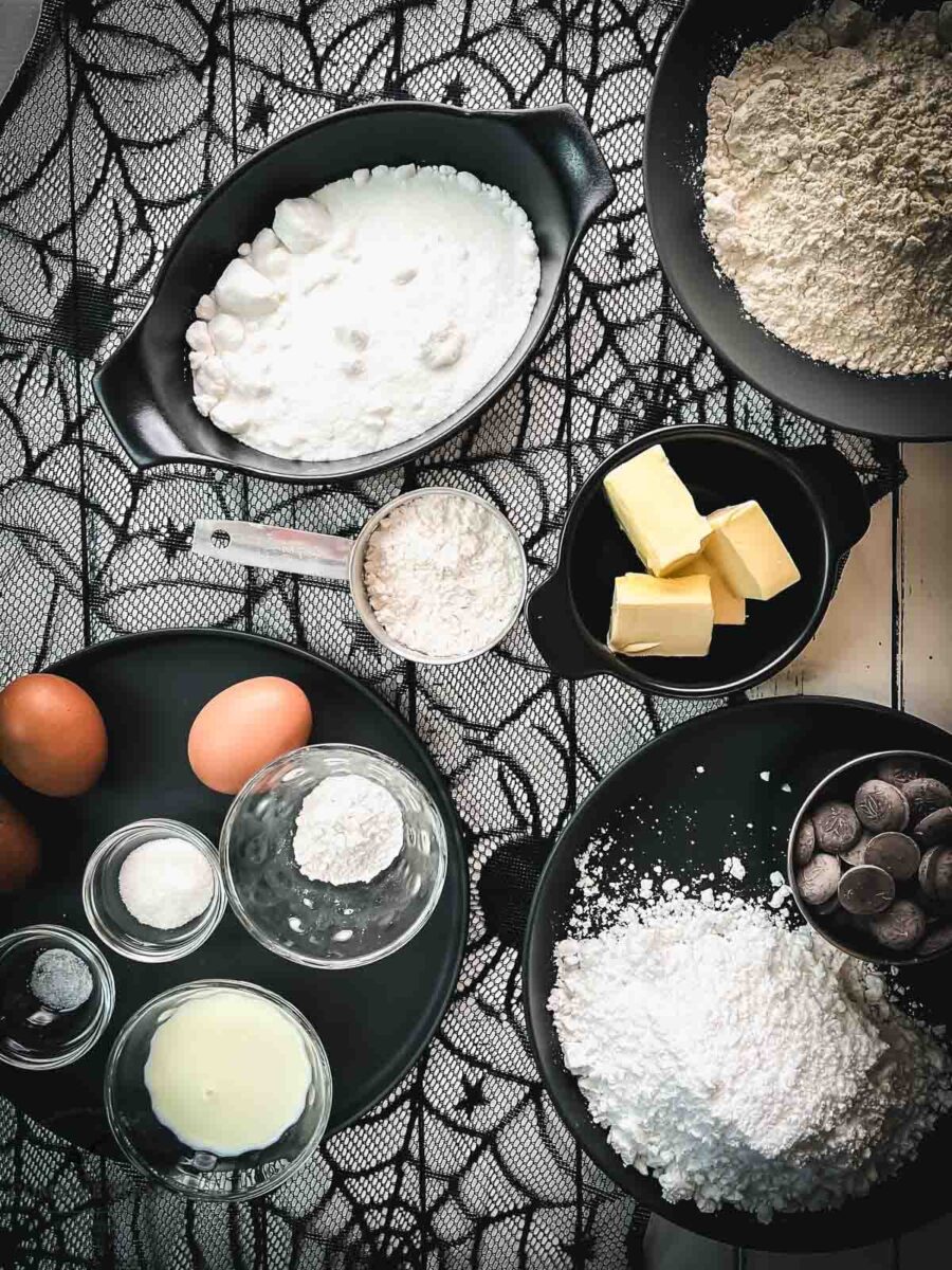 Halloween spiderweb cookies ingredients - flour, butter, granulated sugar, powdered sugar, eggs, milk, chocolate couverture, lemon juice, baking powder, and vanilla custard.