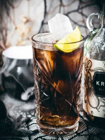 Gorgeous highball glass filled with delicious Kraken Cola. Served spookily next to a little spider on a spider web.