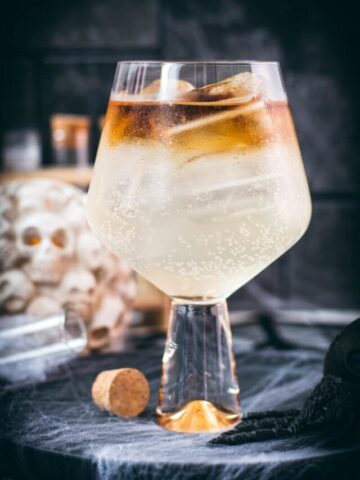 Gorgeous layered kraken ginger beer cocktail with spooky decoration.