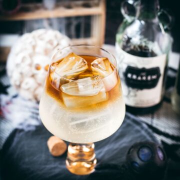 Gorgeous layered kraken ginger beer cocktail with spooky decoration.