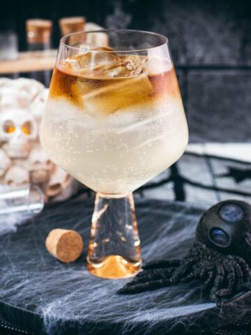 Gorgeous layered kraken ginger beer cocktail with spooky decoration.