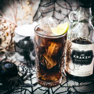 Gorgeous highball glass filled with delicious Kraken Cola. Served spookily next to a little spider on a spider web.