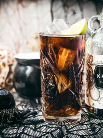 Gorgeous highball glass filled with delicious Kraken Cola. Served spookily next to a little spider on a spider web.