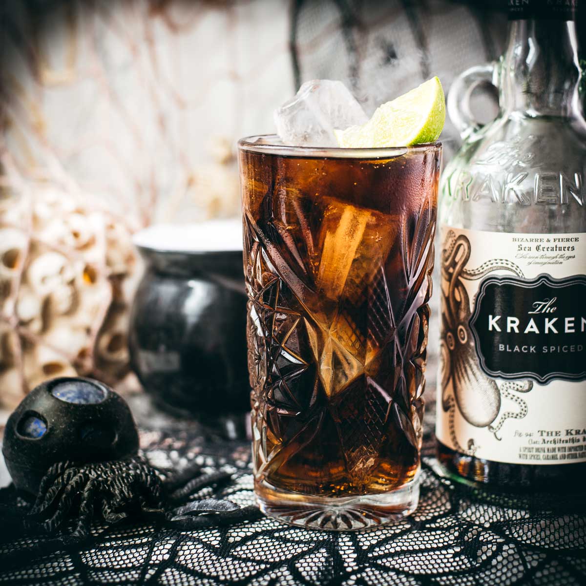 Gorgeous highball glass filled with delicious Kraken Cola. Served spookily next to a little spider on a spider web.