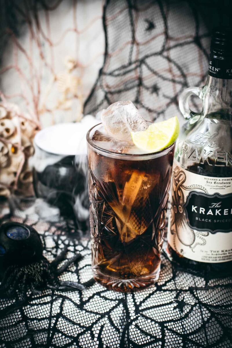 Gorgeous highball glass filled with delicious Kraken Cola. Served spookily next to a little spider on a spider web.