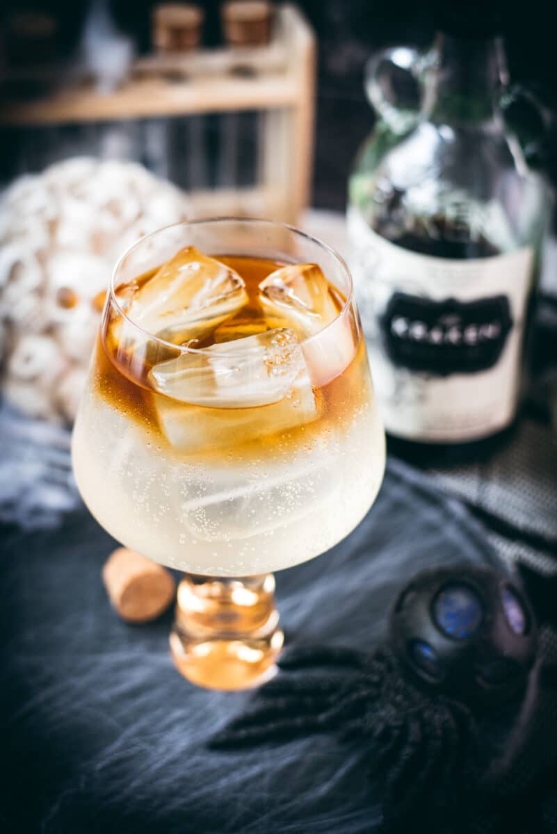 Gorgeous layered kraken ginger beer cocktail with spooky decoration.