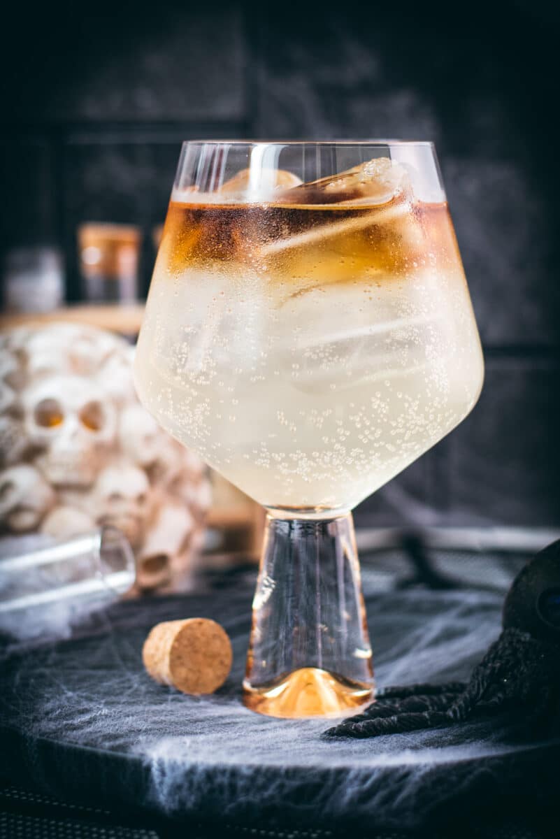 Gorgeous layered kraken ginger beer cocktail with spooky decoration.