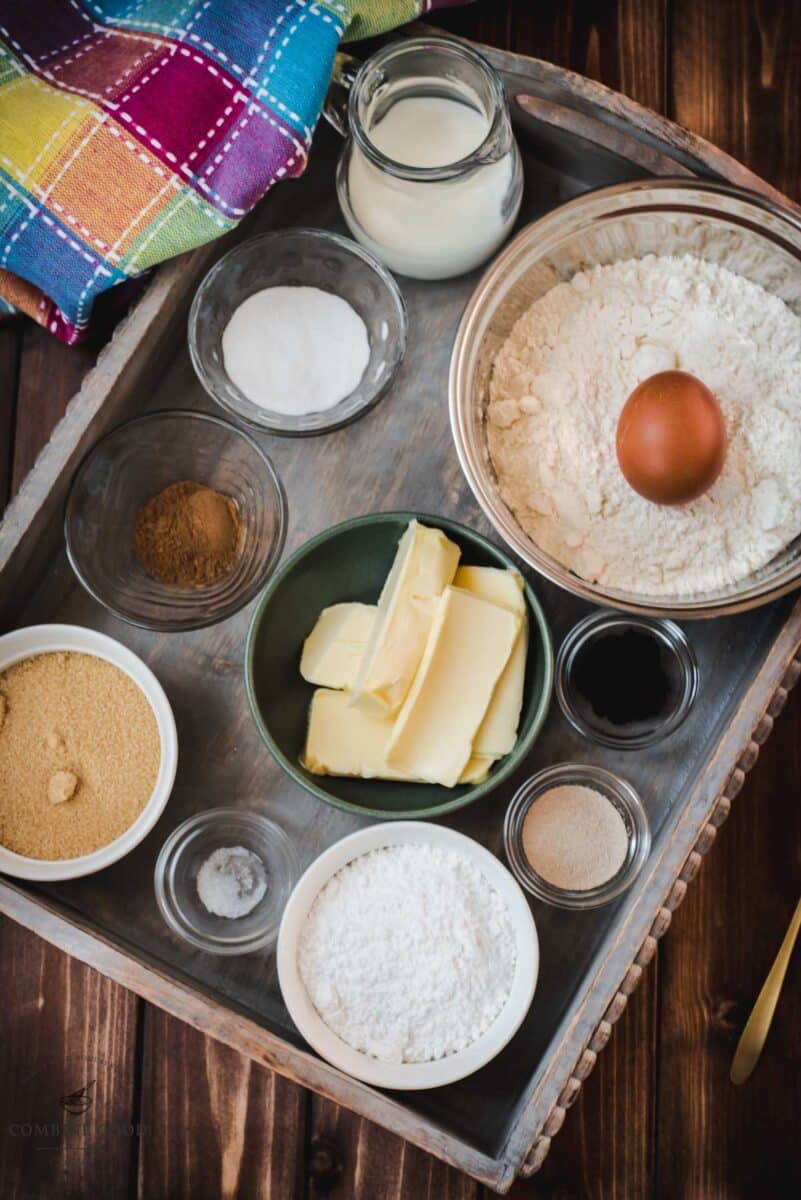 Ingredients for mini cinnamon rolls - egg, dry yeast, butter, flour, vanilla. milk, cinnamon, sugar, brown sugar, salt, powdered sugar.