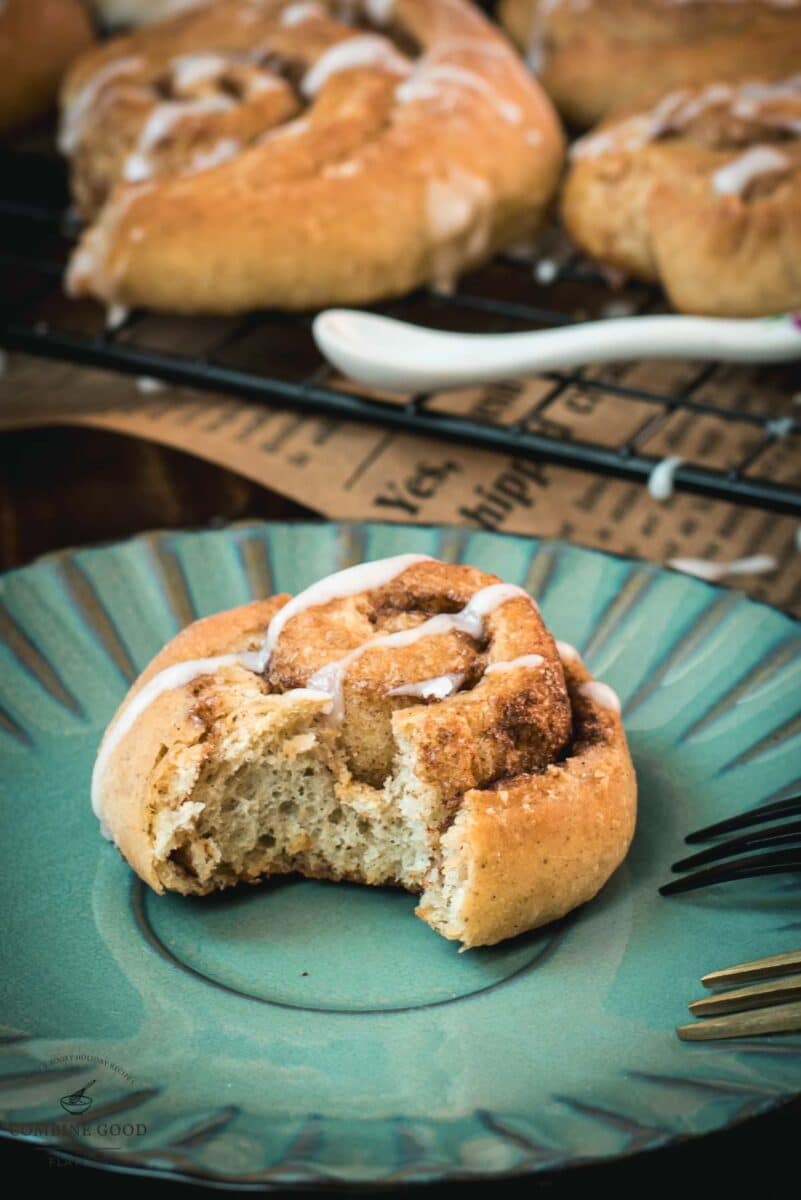 Yummy mini cinnamon rolls, drizzled with homemade sugar icing, placed on teal colored plate.