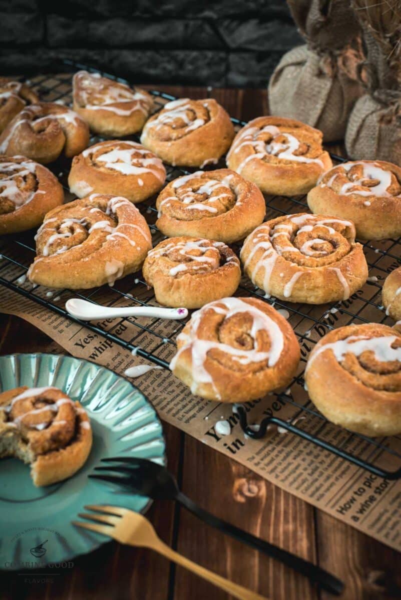 Yummy mini cinnamon rolls, drizzled with homemade sugar icing, placed on cooling rack.