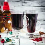 Gorgeous glasses filled with mulled placed next to Christmas decor.