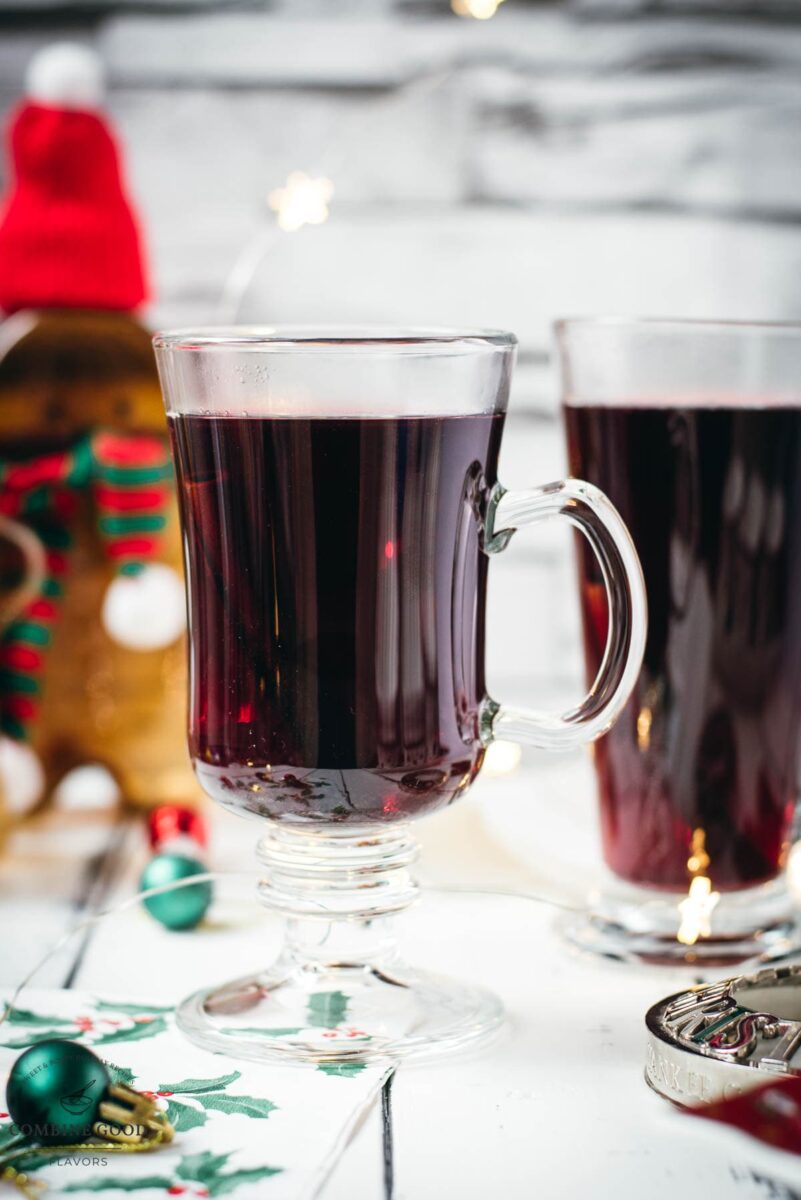 Gorgeous glasses filled with mulled placed next to Christmas decor.